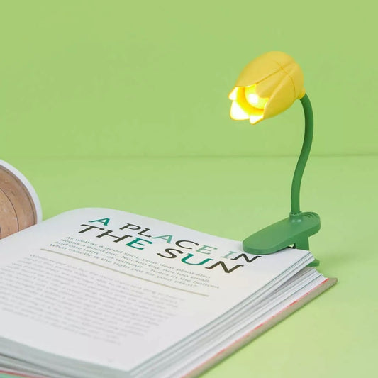 Lampe tulipe jaune fixée sur un livre pour lire la nuit
