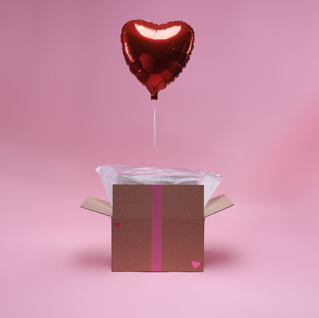Ballon cœur rouge gonflé à l'hélium qui sort de sa boîte