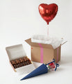 Box ballon cœur rouge ouverte avec message personnalisé et chocolats artisanaux