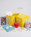 Coffret cadeau surprise jaune “?” avec carnet arc-en-ciel, bougie parfum guimauve et accessoires kawaii.
