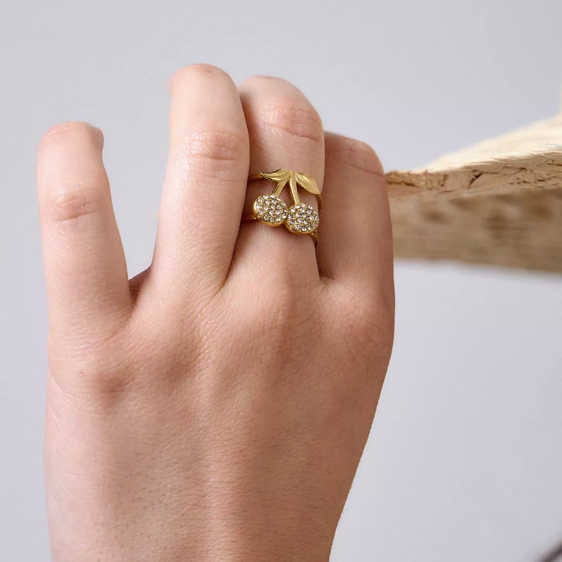 Bague ajustable cerises portée sur main féminine – accessoire tendance
