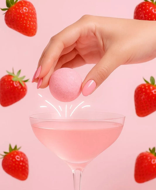 Bombe à cocktail fraises des bois tenue au-dessus d’un verre rose