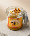 Bougie miel artisanale 100g présentée avec un second format sur plateau en rotin