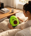 Femme tenant une bouillotte peluche avocat pour un moment de détente