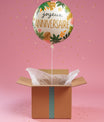 Box surprise anniversaire avec ballon Tropical en hélium, carte message personnalisée et papier de soie blanc.