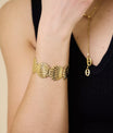 Bracelet coquillage porté au poignet féminin – bijou doré chic