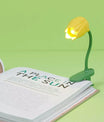 Lampe tulipe jaune fixée sur un livre pour lire la nuit